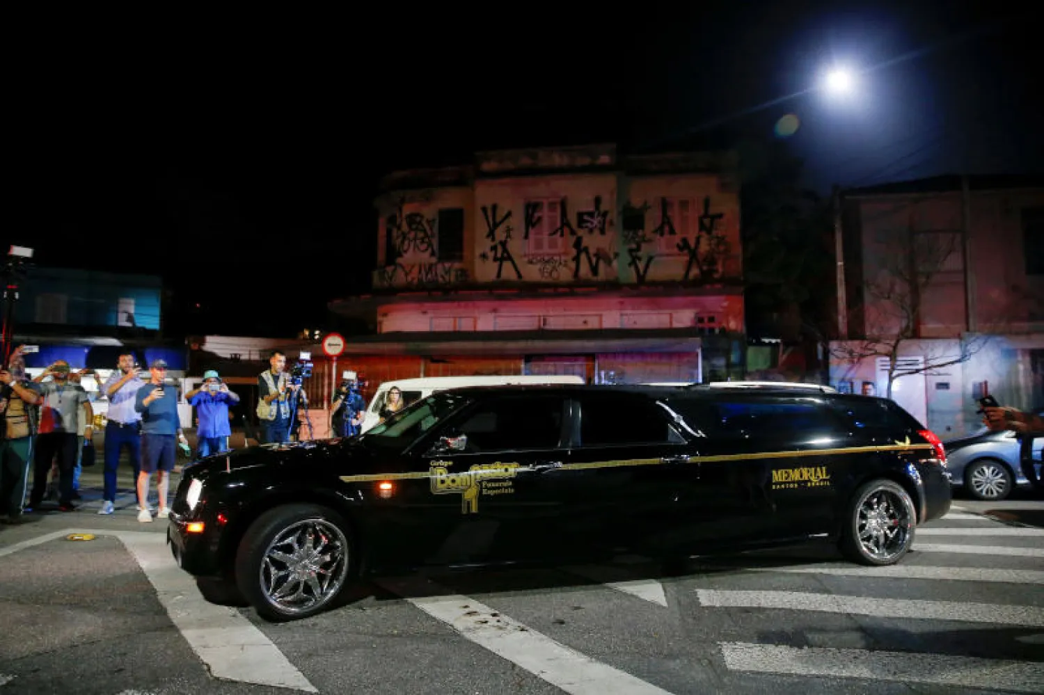 سيارة تنقل جثة أسطورة كرة القدم البرازيلية بيليه بالقرب من ملعب فيلا بيلميرو في سانتوس بالبرازيل (رويترز)