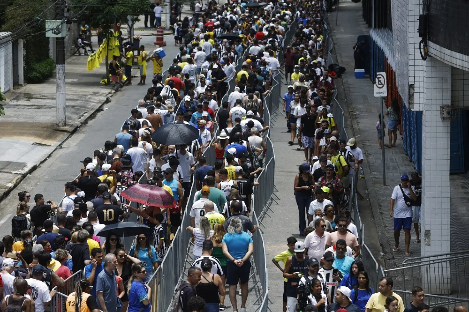 Mourners queue to pay their respect to Brazilian soccer legend Pele, as his body lies in state on the pitch of his former club Santos' Vila Belmiro stadium, January 2, 2023. (Reuters)