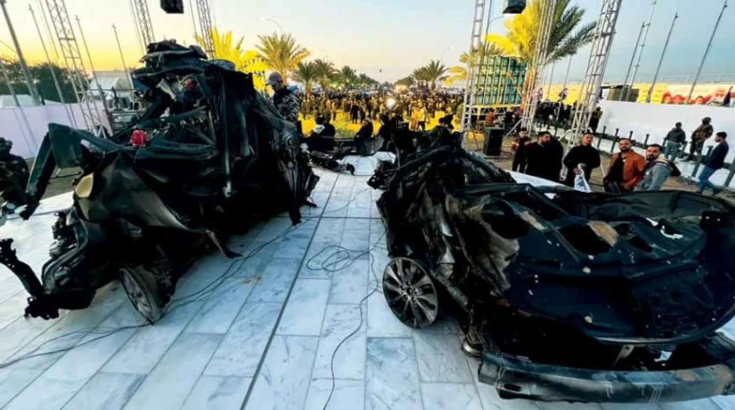 حطام السيارتين اللتين قتل فيهما سليماني والمهندس تحول نصباً لهما قرب مطار بغداد وزاره أنصار الفصائل الموالية لإيران أمس (أ.ب)