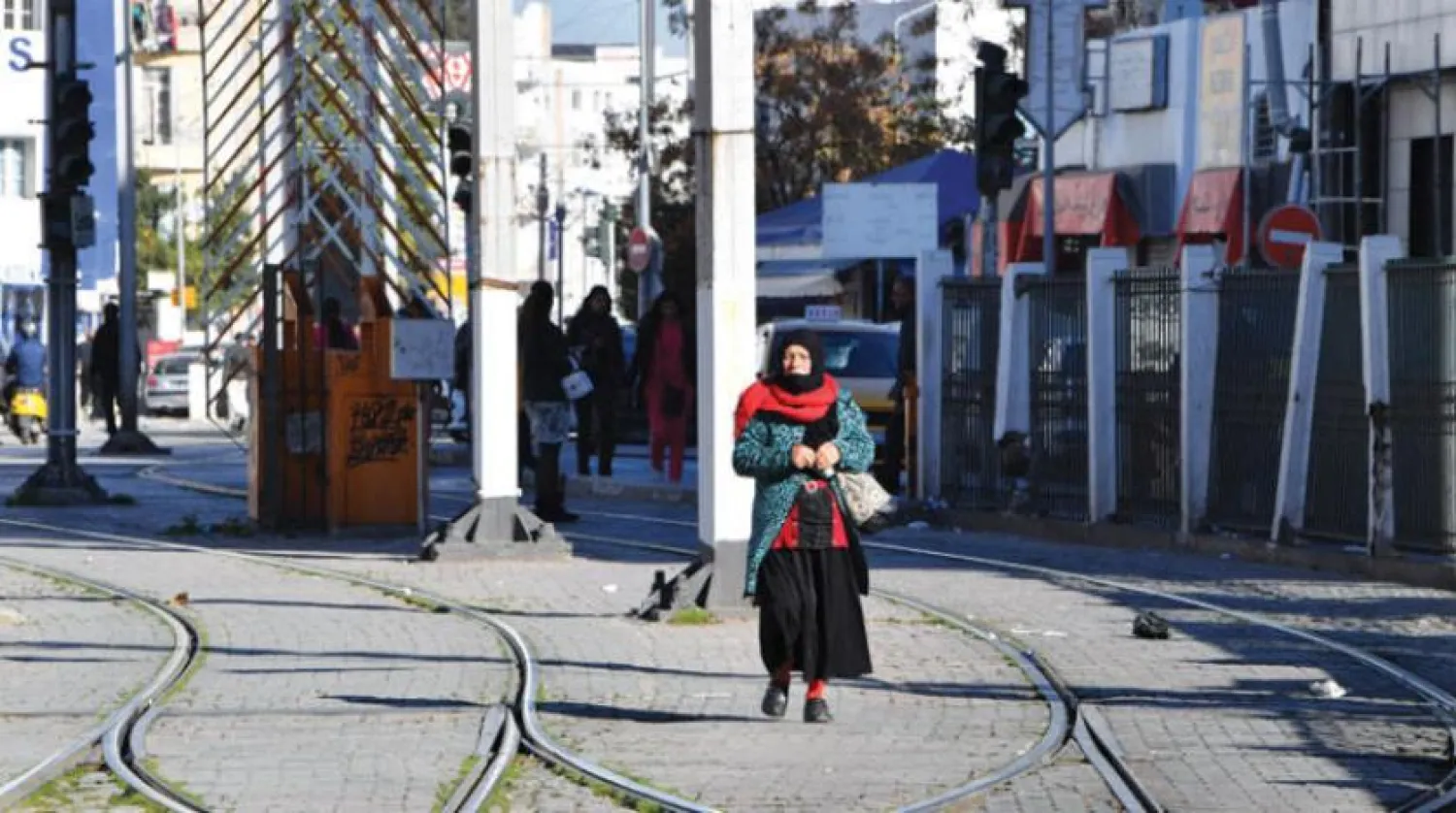 A Tunisian woman walks on one of the tram lines after organizing a widespread strike in the transport sector in the capital on Monday (AFP)
