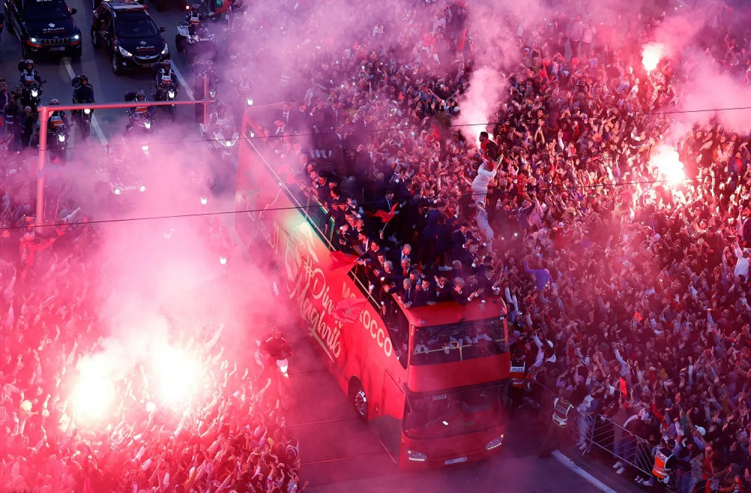 Football - FIFA World Cup Qatar 2022 - Morocco return after the World Cup - Rabat, Morocco - December 20, 2022 Fans celebrate with flares as Morocco players arrive on a bus. (Reuters)