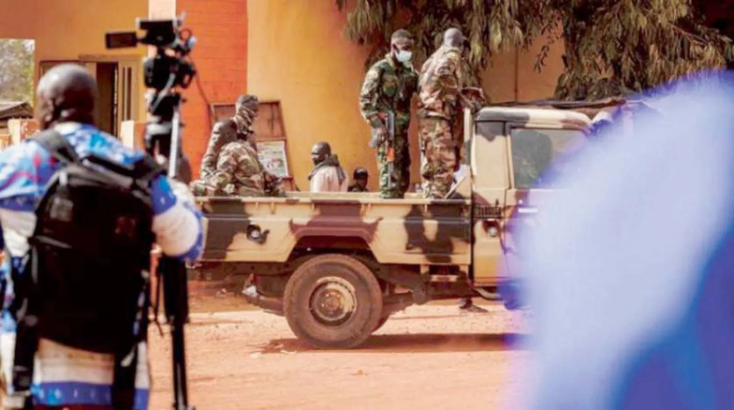 صحافيون وعسكريون ينتظرون خارج محكمة الاستئناف في باماكو إبان محاكمة 46 جندياً عاجياً (أ.ف.ب)