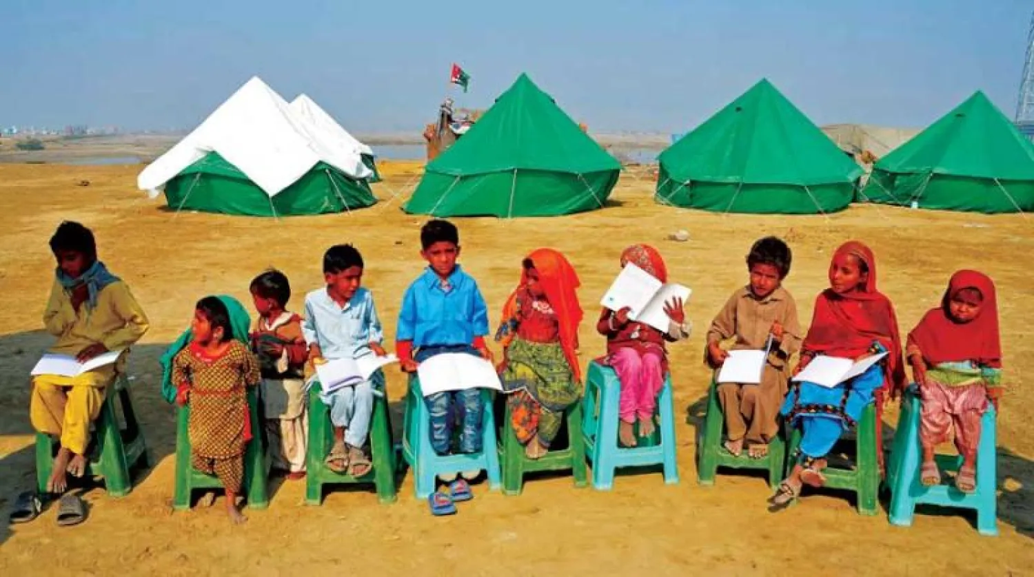 أطفال نازحون بسبب الفيضانات يحضرون درساً في مدرسة متنقلة بمخيم في جعفر آباد بإقليم بلوشستان أمس (أ.ف.ب)