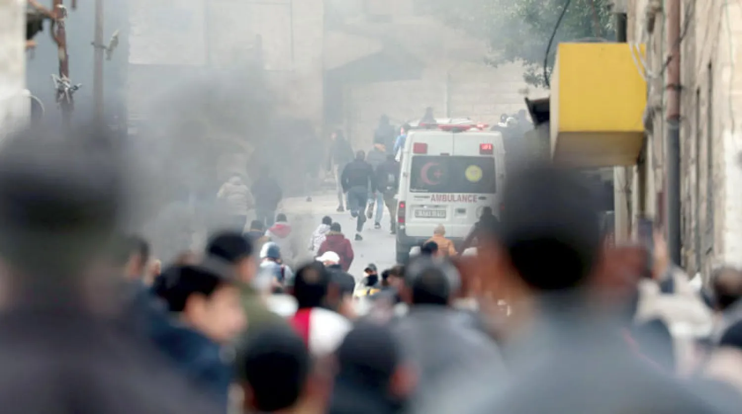 فلسطينيون يحتمون من توغل عسكري إسرائيلي في مدينة نابلس شمال الضفة (إ.ب.أ)