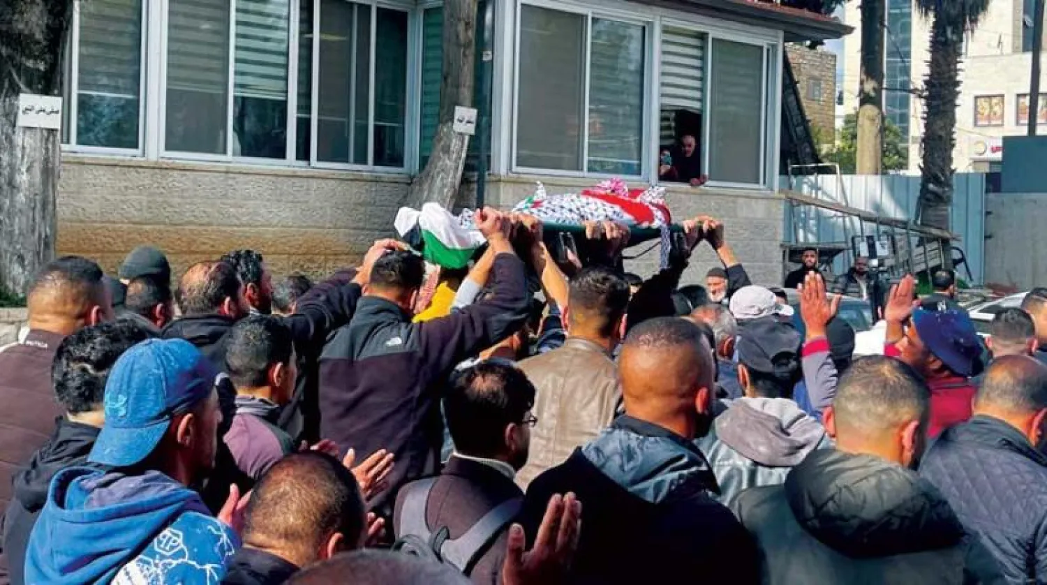 مشيعون ينقلون جثمان الفلسطيني أحمد كحلة (45) عاما خارج المستشفى في رام الله بالضفة الغربية الأحد (رويترز)