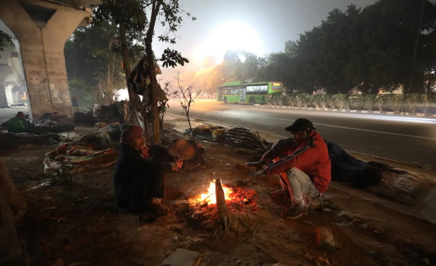 مشردون يتدفأون في أحد شوارع نيودلهي (إ.ب.أ)