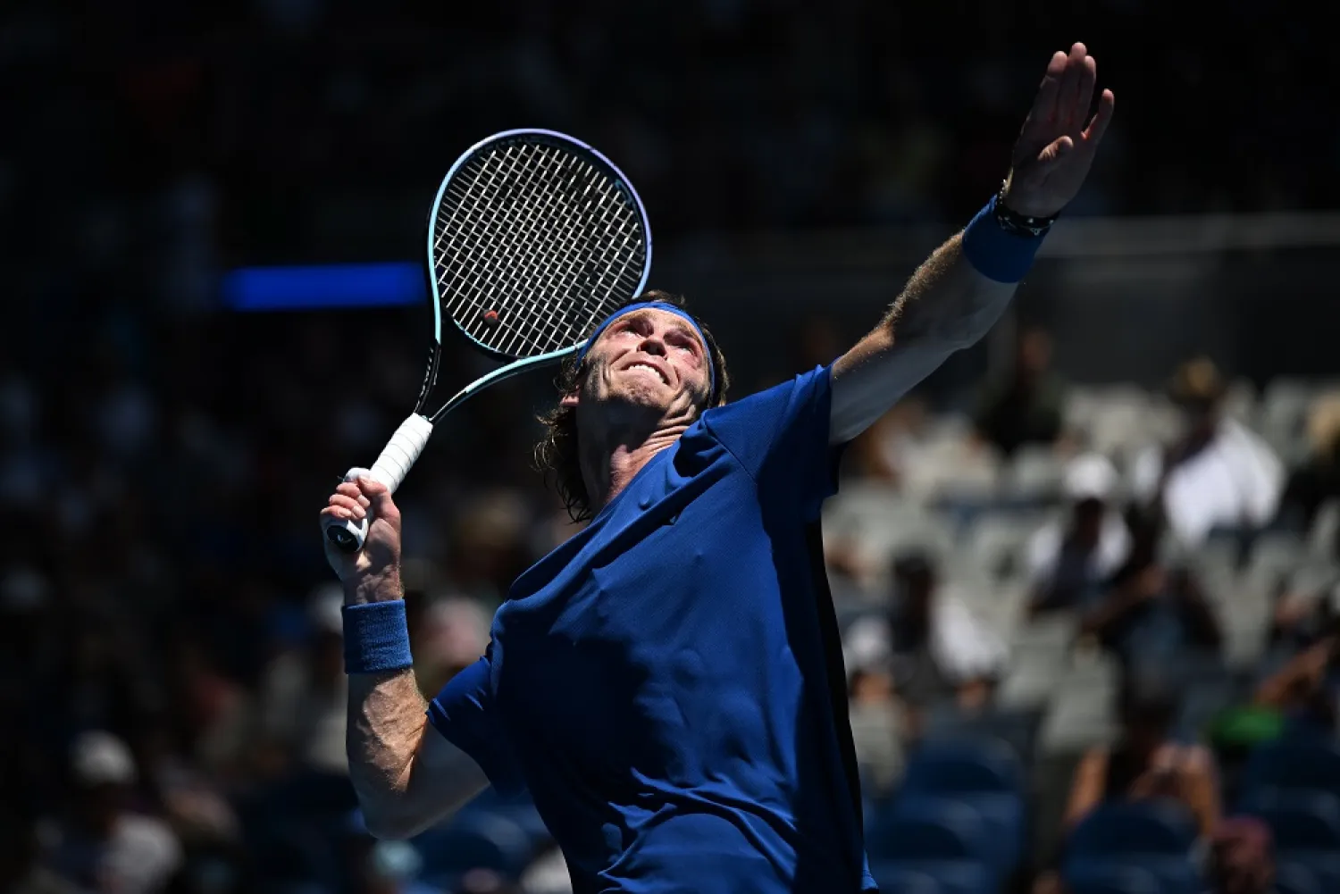 Andrey Rublev of Russia prepares to serve to Dominic Thiem of Austria during their first round match at the 2023 Australian Open tennis tournament at Melbourne Park in Melbourne, Australia, 17 January 2023. (EPA)