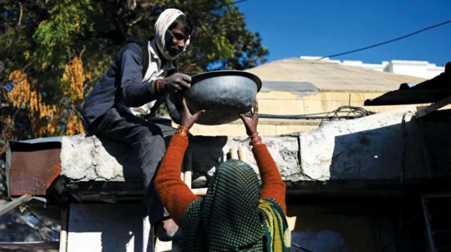 Local construction workers work on the roof of a house in New Delhi, India (AFP)