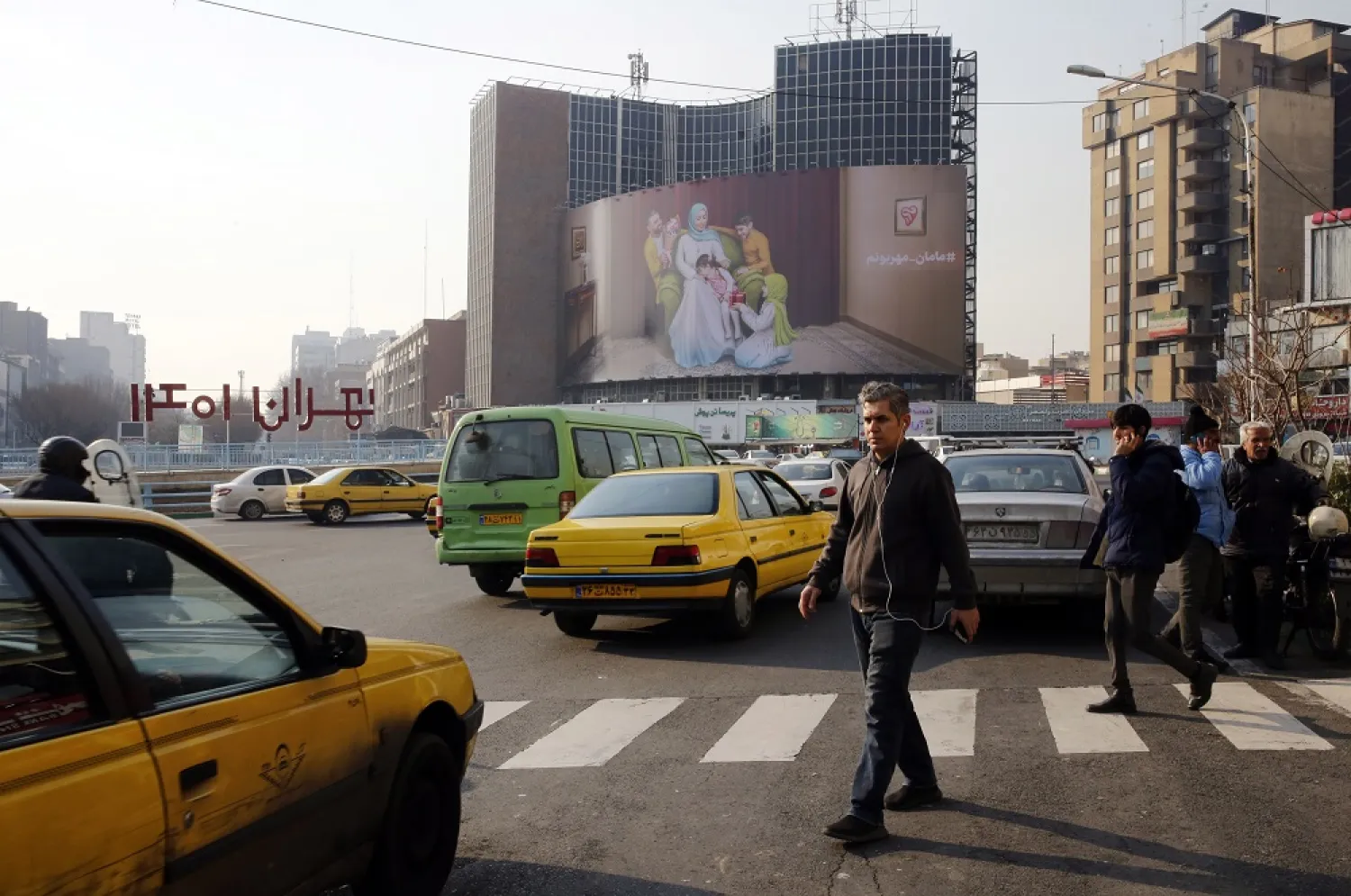Iranians walk in a street in Tehran, Iran, 16 January 2023. (EPA)