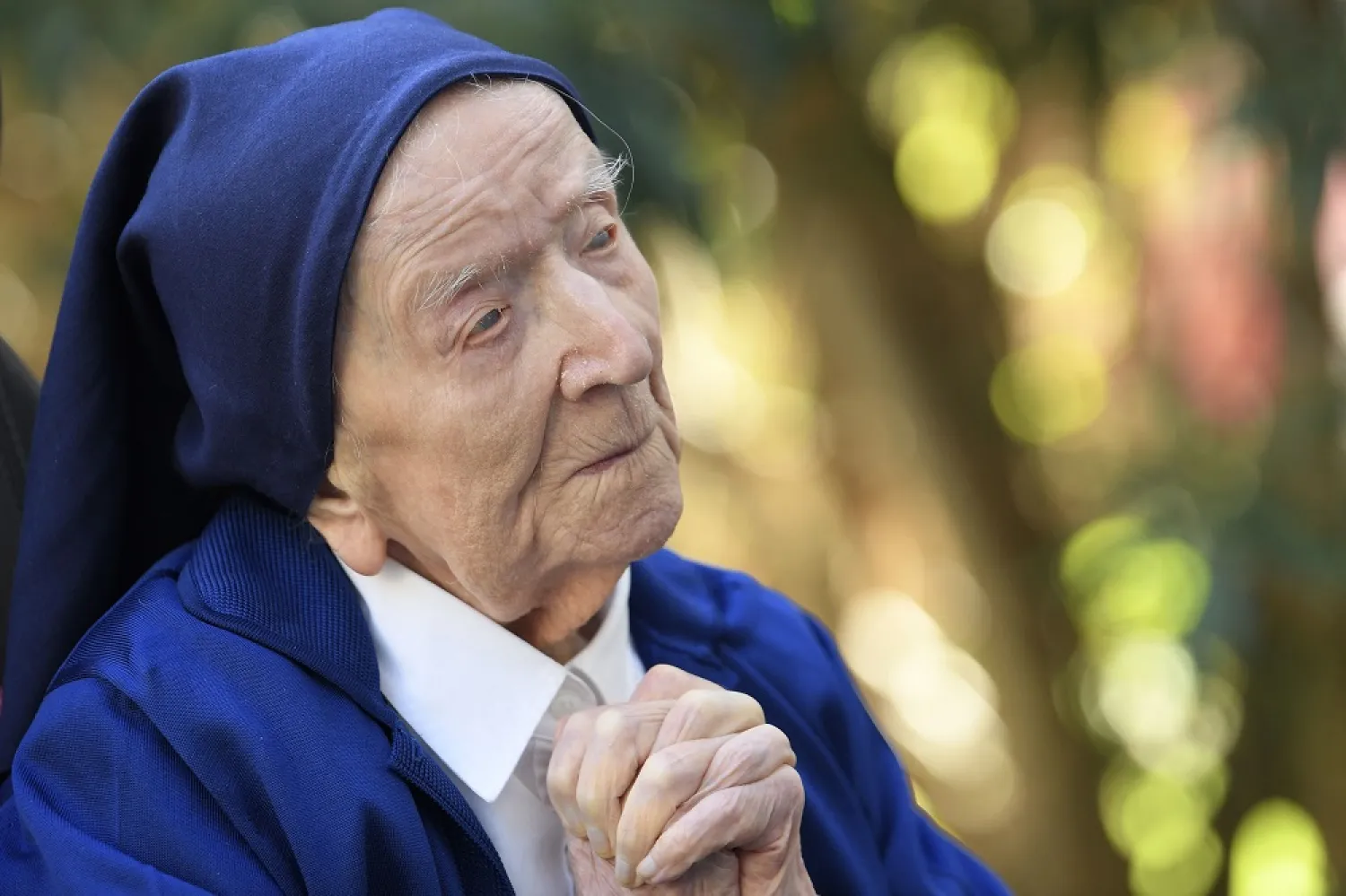 In this file photo taken on February 10, 2021, Sister André, Lucile Randon in the registry of birth, the eldest French and European citizen, prays in a wheelchair, on the eve of her 117th birthday, in an EHPAD (Housing Establishment for Dependent Elderly People) in Toulon, southern France, where she has been living since 2009. (AFP)
