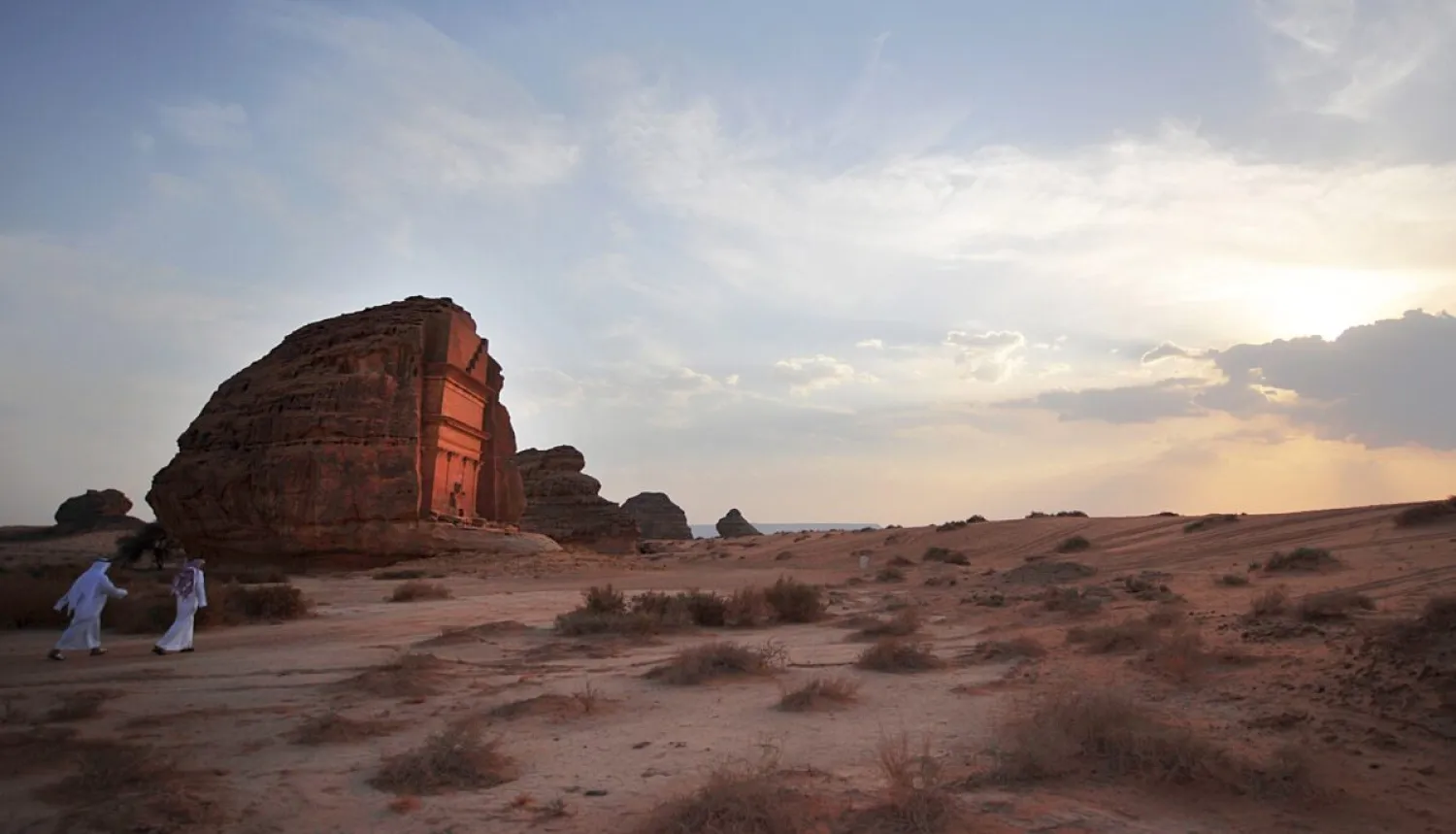 Saudi men walking near a carved rose-coloured sandstone
mountain in the Nabataean archaeological site of al-Hijr near the
northwestern town of AlUla, Saudi Arabia, on Sept. 30, 2012. (FAYEZ
NURELDINE/AFP/GettyImages)
