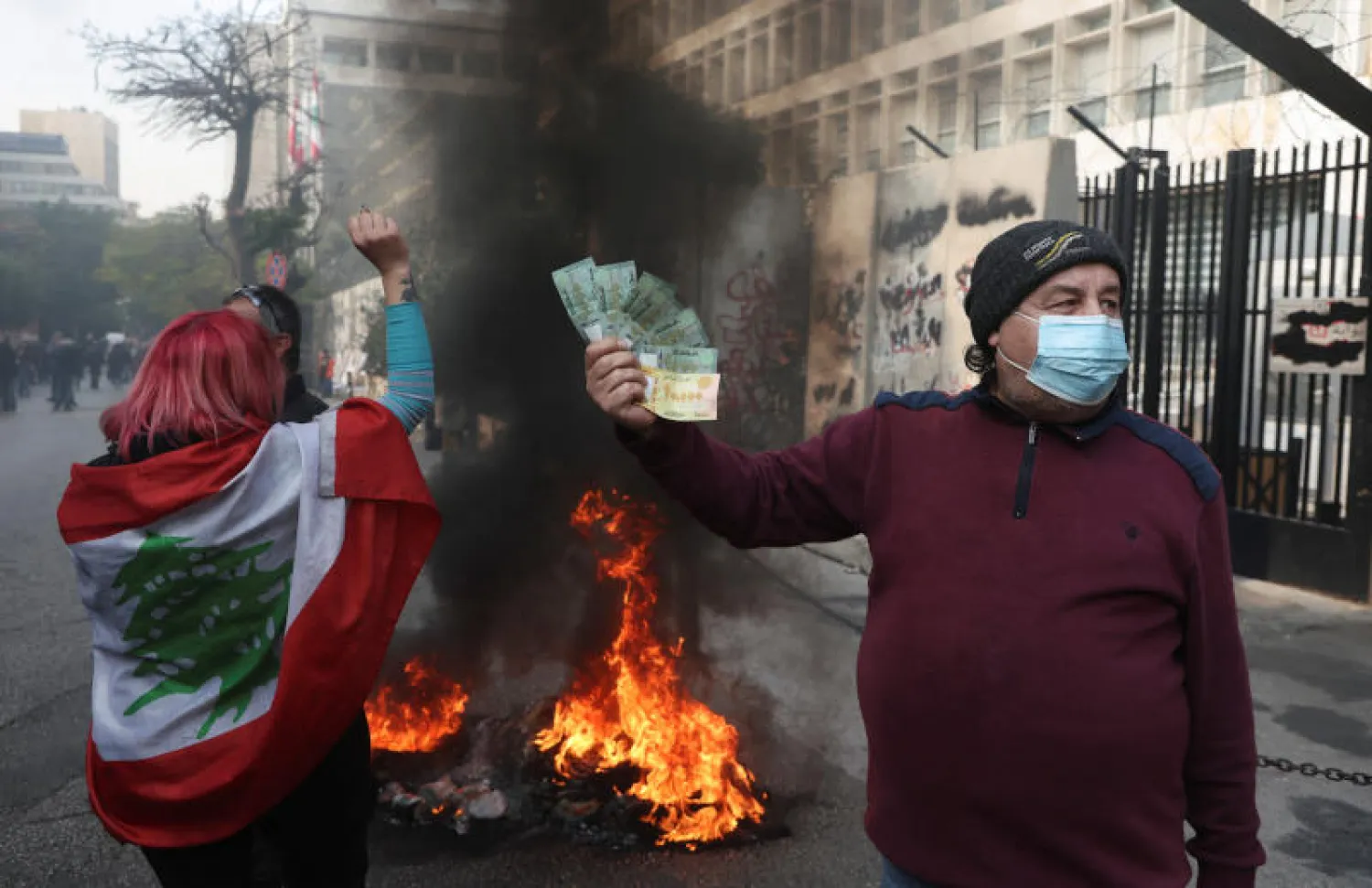 محتجون يقطون الشارع أمام مبنى مصرف لبنان المركزي في بيروت (رويترز)