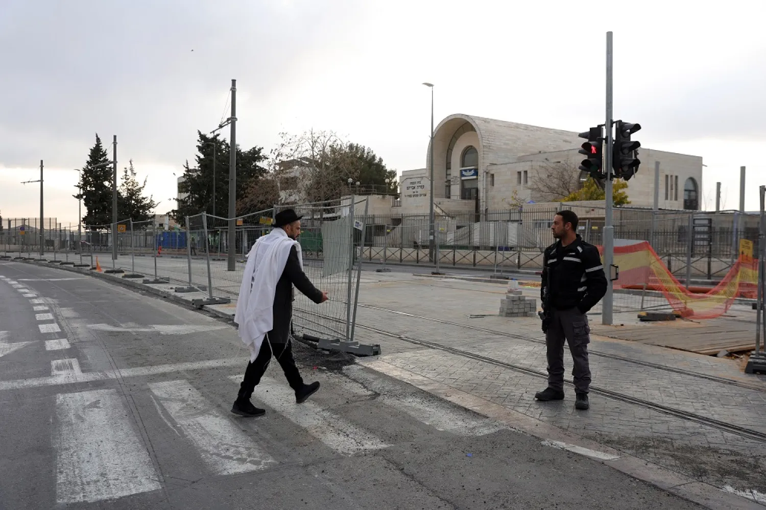 A Police officer (R) outside the Ataret Avraham Synagogue in the Neve Yaakov neighborhood after a fatal shooting attack in Jerusalem, 28 January 2023. (EPA)