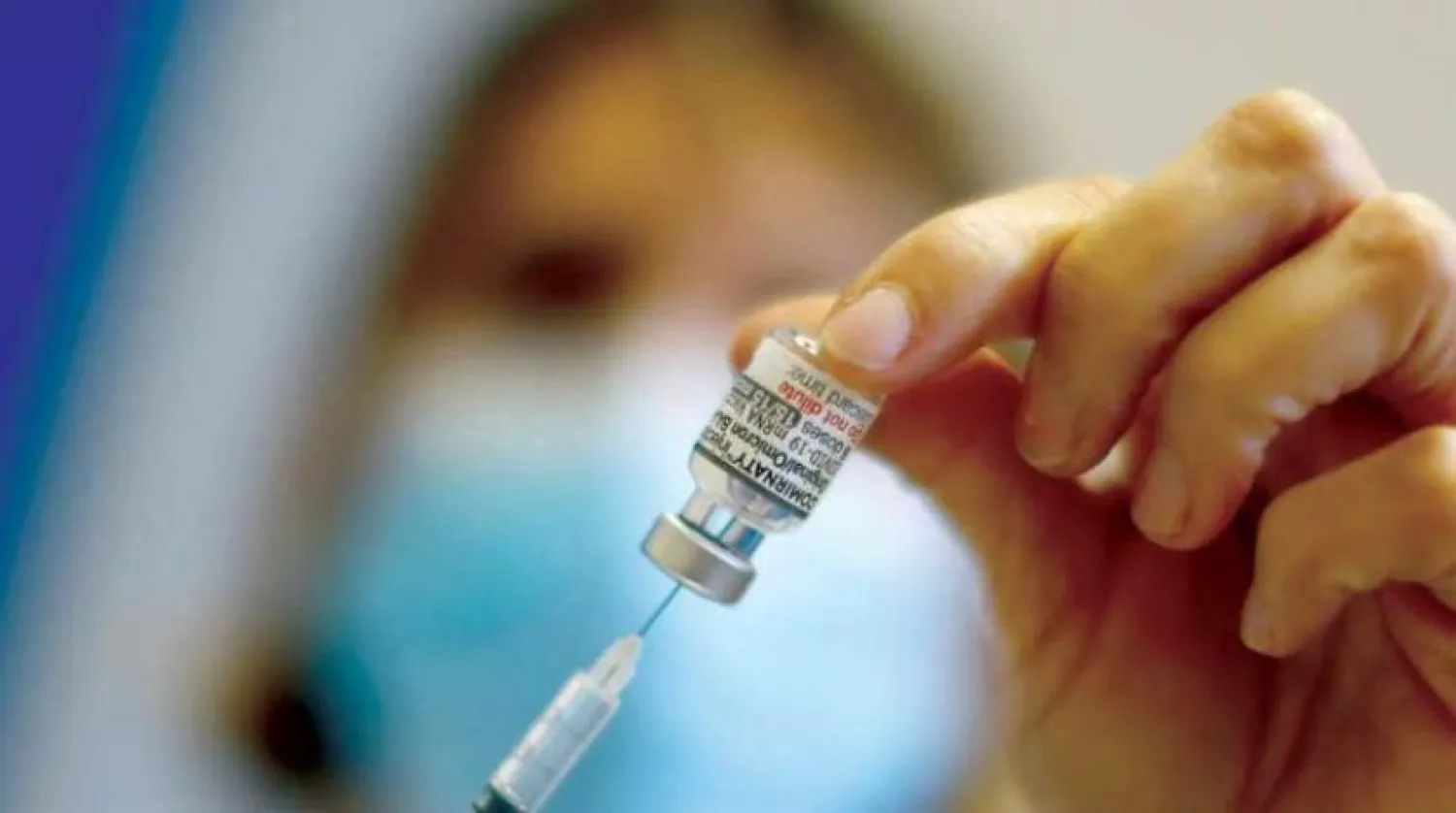 Geçen yıl aralık ayında aşı merkezinde bir doz Pfizer-BioNTech aşısı hazırlayan hemşire (Reuters)