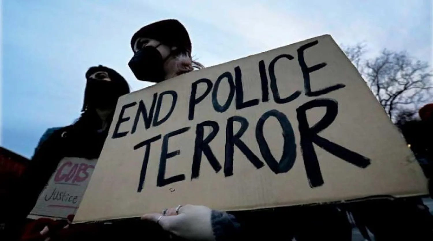 متظاهر يحمل لافتة تقول: «أوقفوا رعب الشرطة» خلال احتجاج في نيويورك أول من أمس (إ.ب.أ)