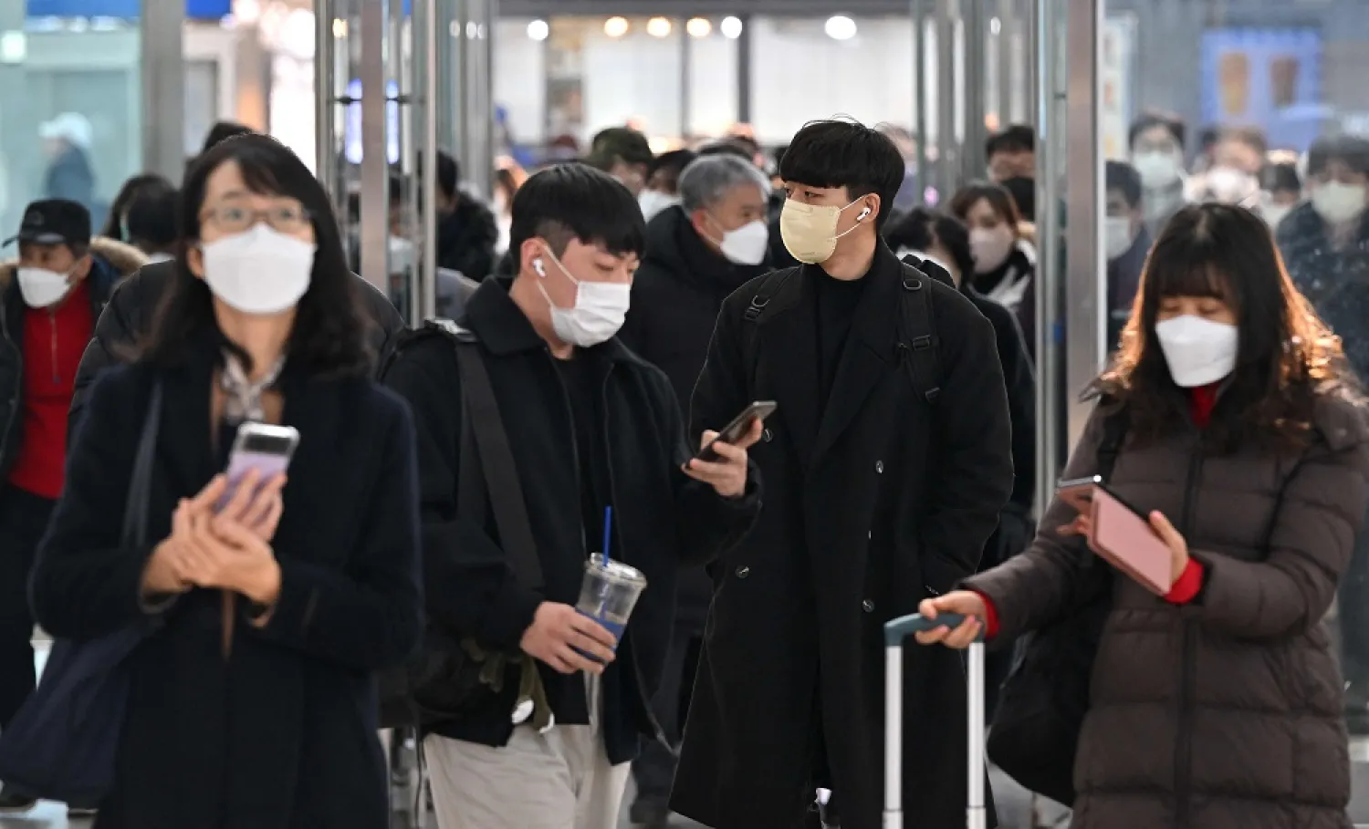 People wearing face masks make their way at Seoul railway station in Seoul on January 30, 2023, after South Korea lifted its indoor mask mandate as COVID cases dwindle. (AFP)