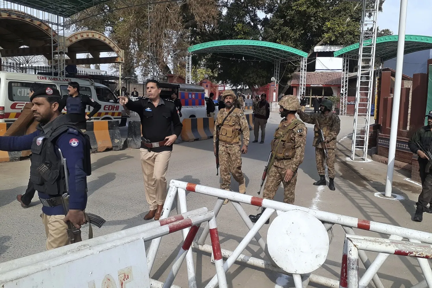 Army soldiers and police officers clear the way for ambulances rushing toward a bomb explosion site, at the main entry gate of police offices, in Peshawar, Pakistan, Monday, Jan. 30, 2023. (AP)
