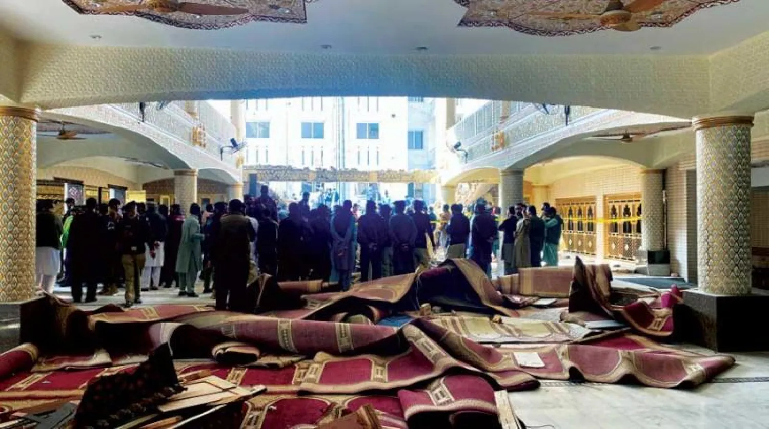 مسؤولون أمنيون وعمال إنقاذ داخل مسجد في مدينة بيشاور الباكستانية شهد انفجاراً أمس (أ.ب)