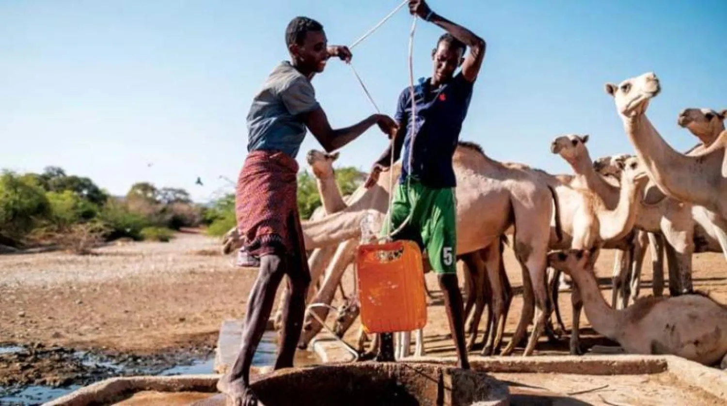Two young men lift a bucket of water from a well in an Ethiopian village. (AFP)