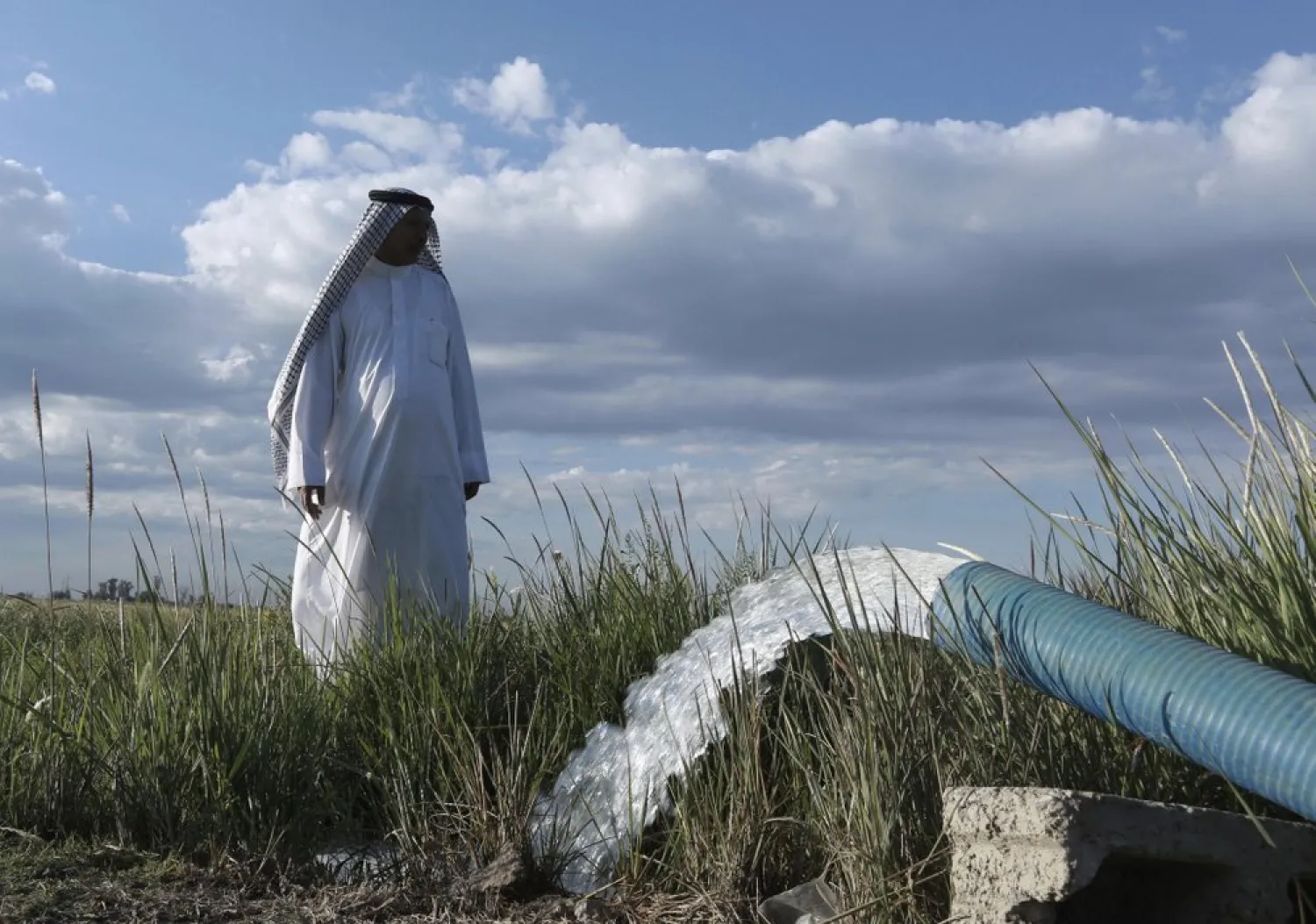 In this Tuesday, April 23, 2019, photo, a farmer stands near a water pump on his farm in Youssifiyah, Iraq. AP