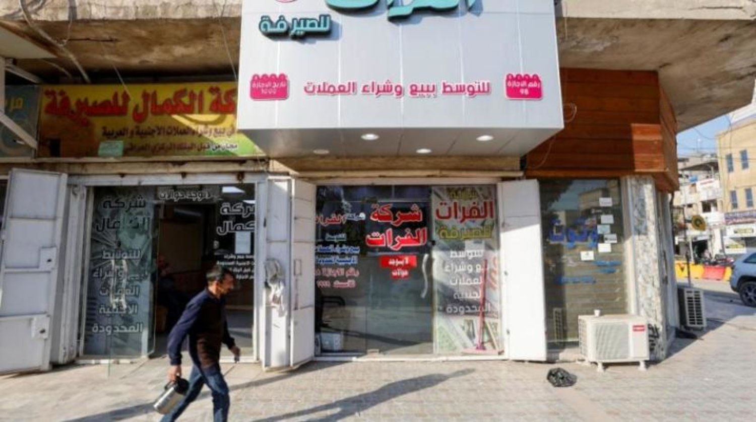 An Iraqi citizen in front of a currency exchange store (Reuters)