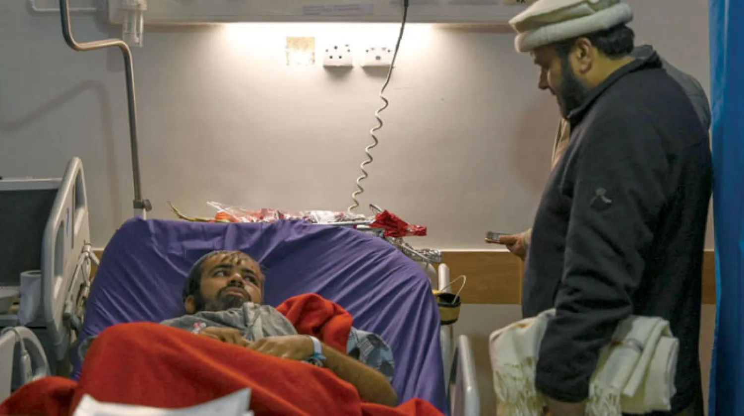 شرطي أُصيب في تفجير المسجد خلال تلقيه العلاج بمستشفى في مدينة بيشاور أمس (أ.ف.ب)