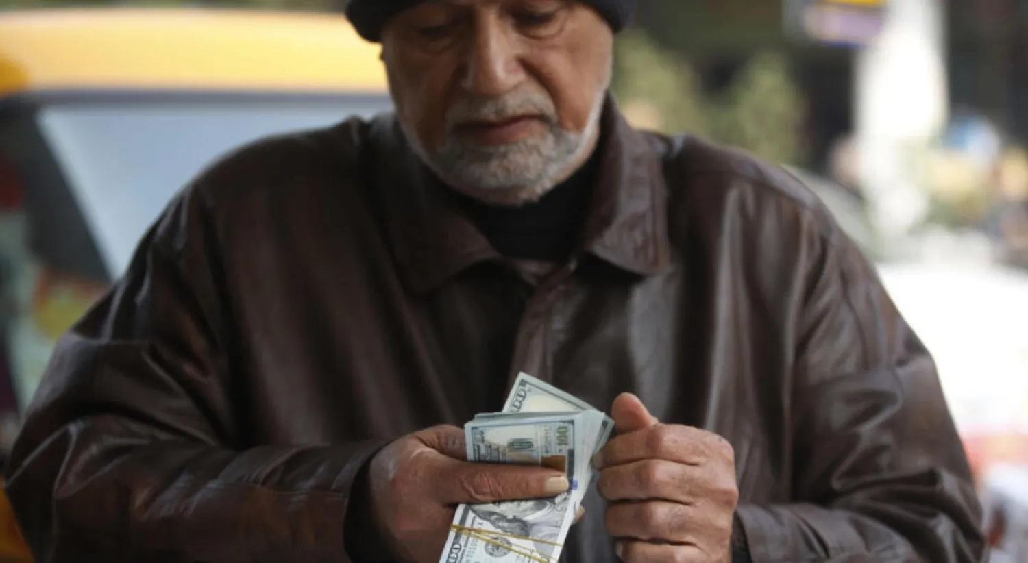 A man counts US dollar banknotes in a Baghdad market on December 27, 2022 as the value of Iraqi dinar against US dollar drops further. © AHMAD AL-RUBAYE / AFP
