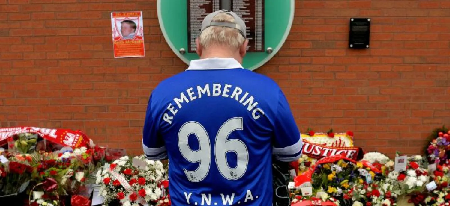 مشجع لإيفرتون يقف أمام نصب تذكاري مؤقت في هيلزبره في الذكرى الـ26 لكارثة هيلزبره (أ.ف.ب)