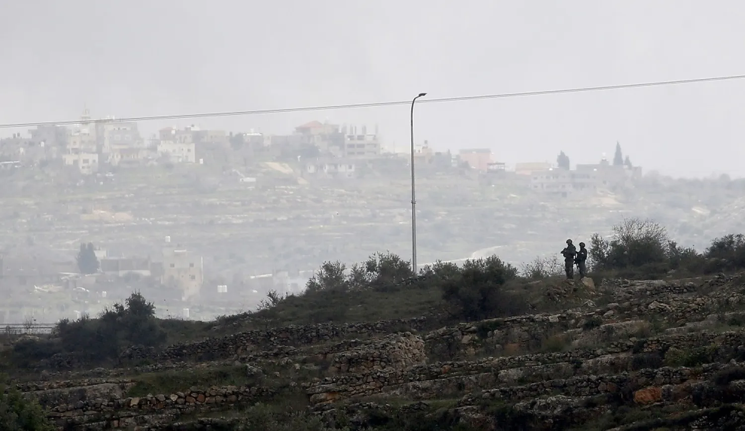 Israeli soldiers watch Palestinians during clashes after a protest against Israeli settlements at Beita village near the West Bank city of Nablus, 03 February 2023. (EPA)