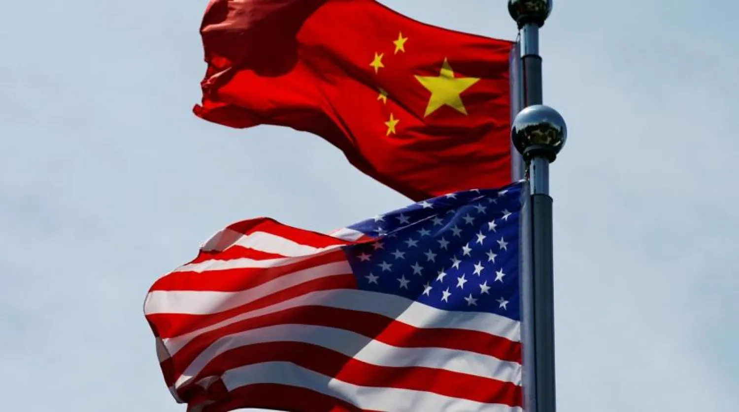 FILE PHOTO: Chinese and US flags flutter in Shanghai, China July 30, 2019. REUTERS/Aly Song
