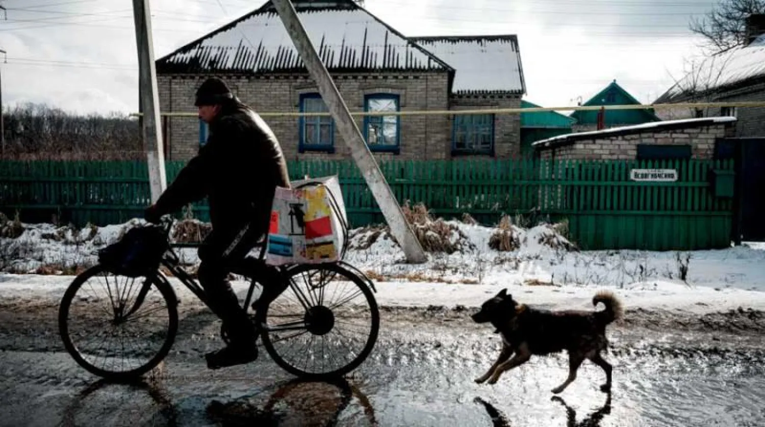 رجل يقود دراجته في قرية بإقليم دونيتسك أمس (أ.ف.ب)