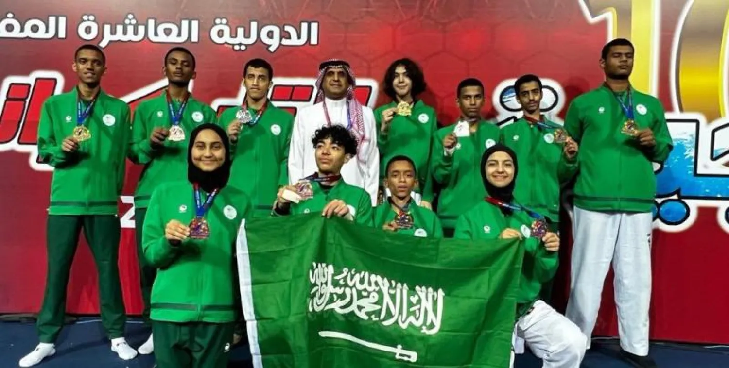 نجوم السعودية يحملون علم بلادهم بعد التتويج في البطولة العربية (موقع الاتحاد السعودي للتايكوندو)
