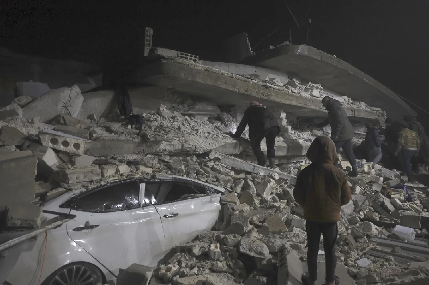 Syrian citizen search through the wreckage of a collapsed building, in Azmarin town, in Idlib province north Syria, Monday, Feb. 6, 2023. (AP)