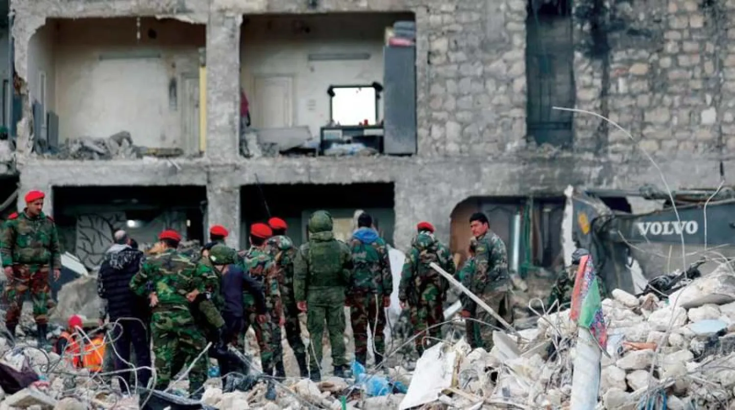 جنود روس وسوريون يتفقدون مبنى تضرر بفعل الزلزال في مدينة حلب شمال سوريا أمس (أ.ب)