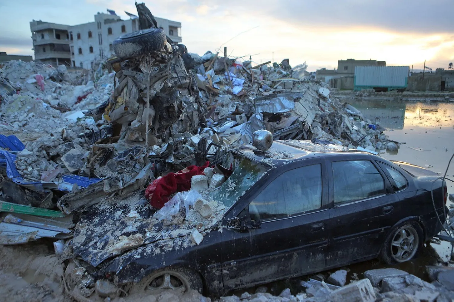 A car sits under the rubble of a collapsed building on February 6, 2022 in the town of Sarmada, in Syria's opposition-held northwestern Idlib province, following a deadly earthquake. (AFP)