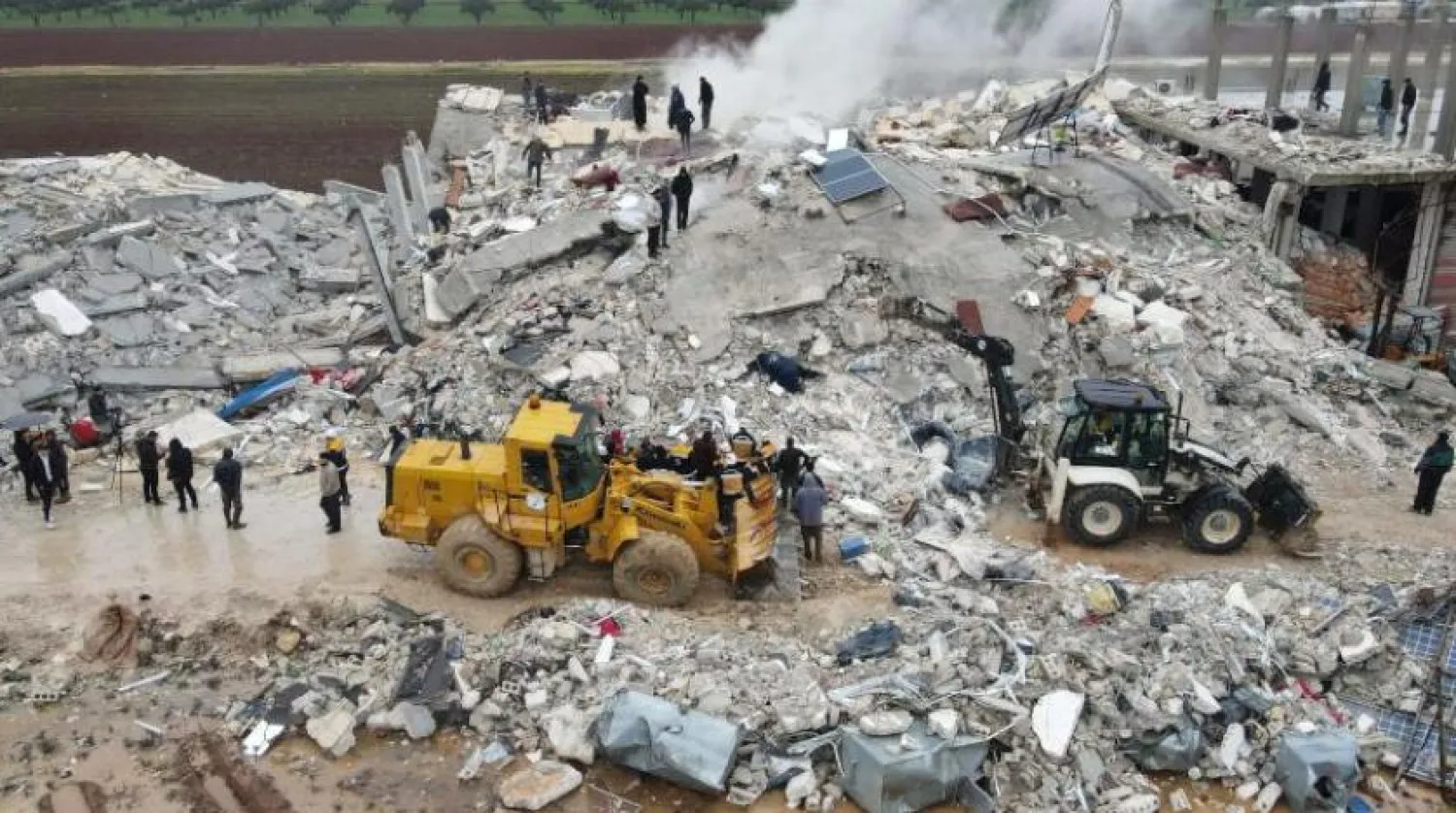 Suriye’nin kuzeybatısındaki İdlib kırsalında bulunan Sarmada kasabasında buldozerlerin yardımıyla enkazı altında kalanlar aranıyor (AFP)