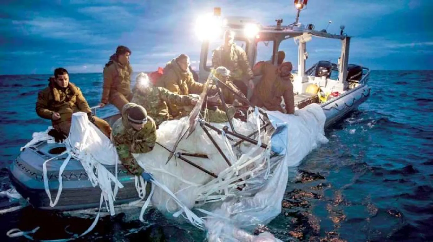 بحارة أميركيون يرفعون جزءاً من المنطاد الصيني الذي تم إسقاطه قبالة ساحل كارولينا الجنوبية (أ.ف.ب)