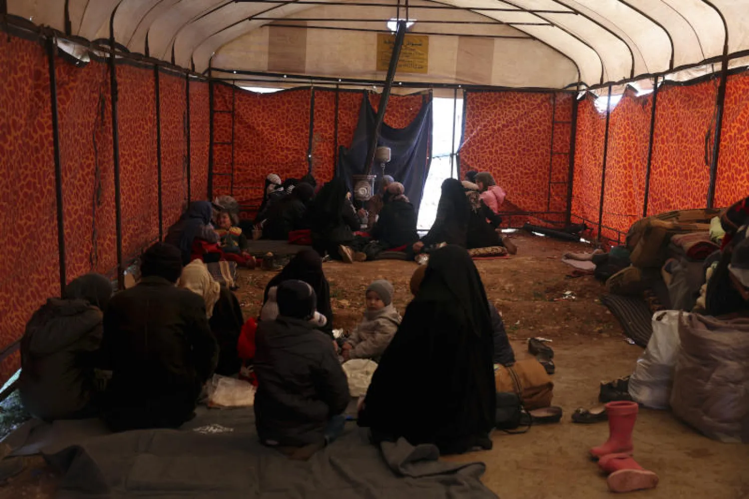 عائلات فقدت منازلها في الزلزال تجلس داخل خيمة قدمتها منظمة غير حكومية (أ.ب)