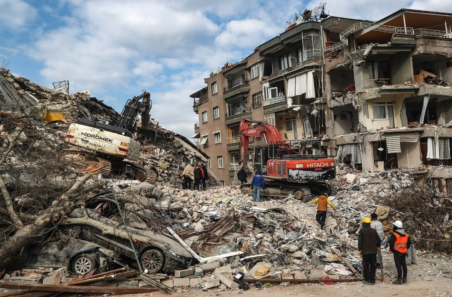 Excavators work on a collapsed building after a powerful earthquake in Hatay, Türkiye, 11 February 2023. (EPA)