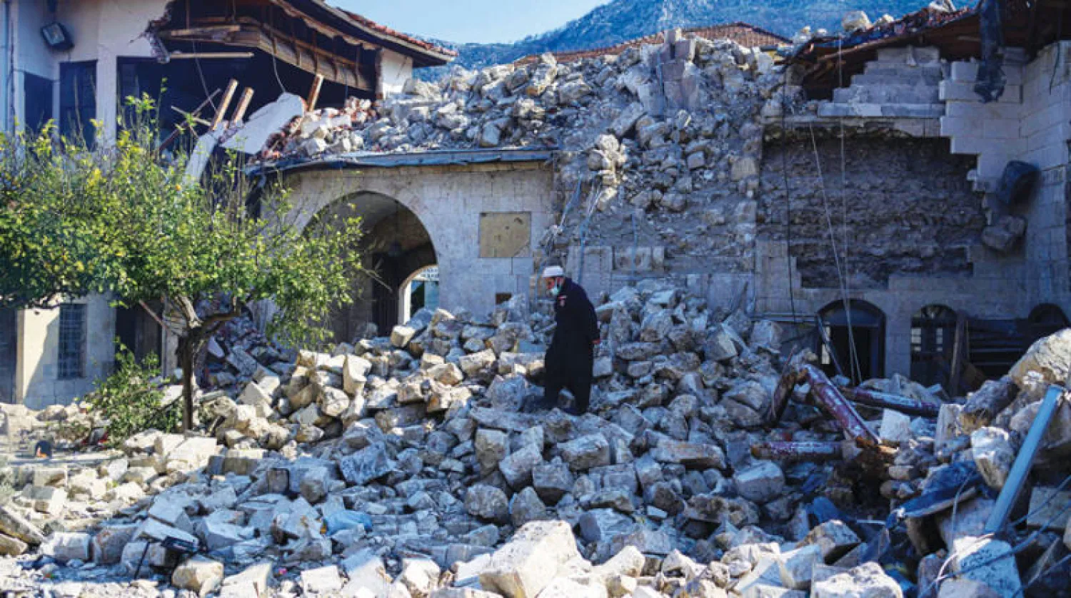 تركي يعاين ركام مسجد دمره الزلزال في مدينة أنطاكيا التاريخية جنوب تركيا أمس (أ.ف.ب)