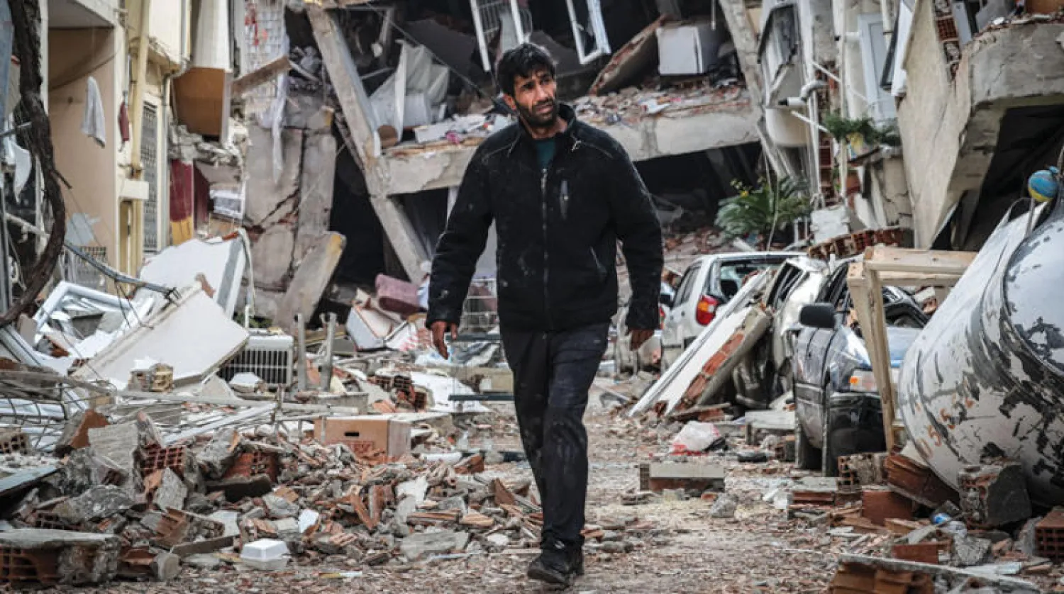 تركي ناج من الزلزال بين مبان مدمرة في أنطاكيا أمس (إ.ب.أ)