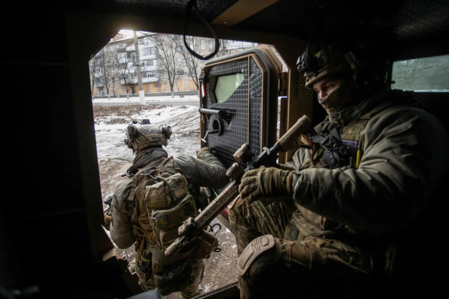 جنديان أوكرانيان يهمان بمغادرة ناقلتهما المدرعة على الجبهة الأمامية في باخموت (رويترز)
