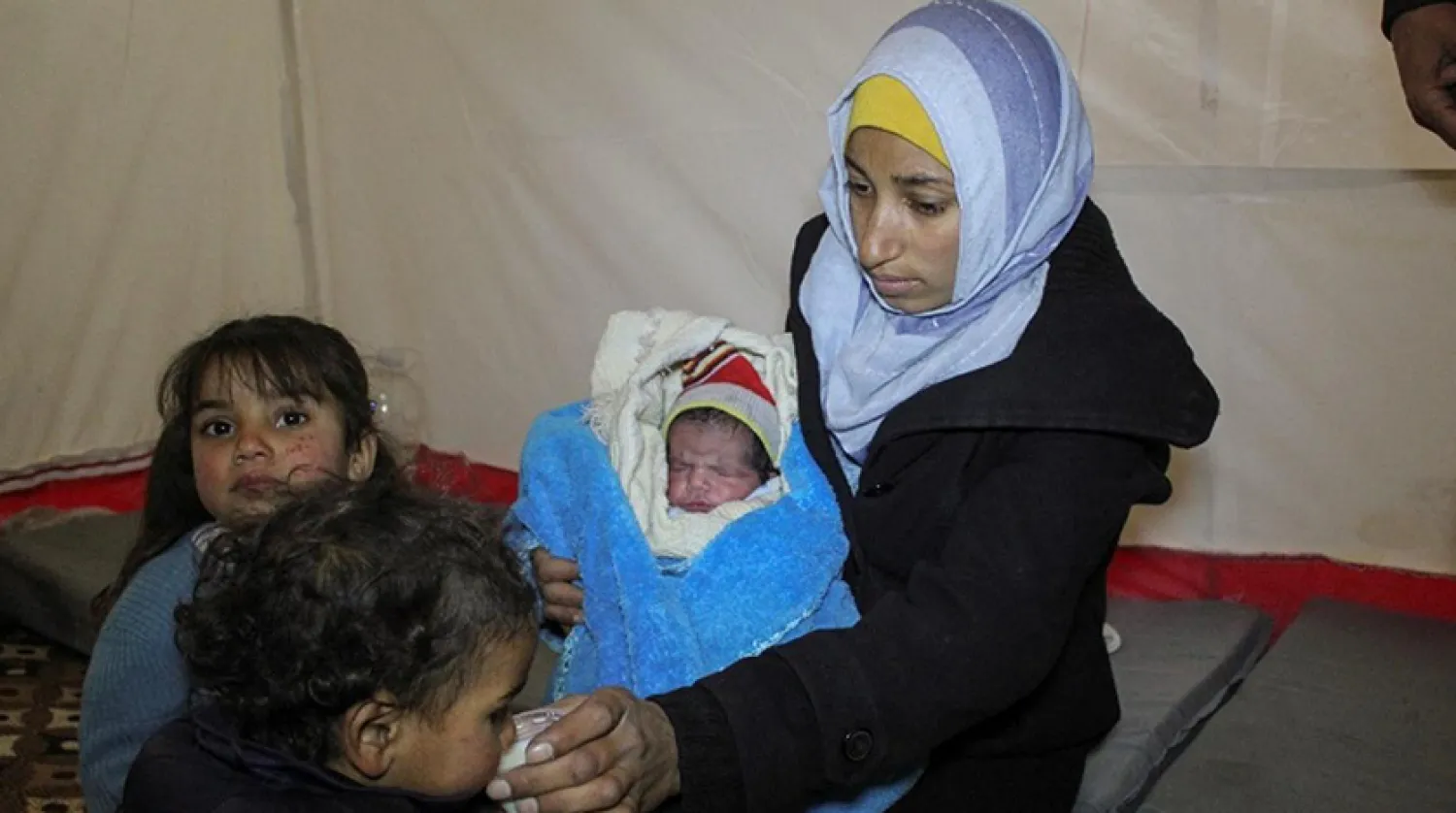 Fatıma Ahmed, deprem günü dünyaya gelen çocuğunu kucaklıyor (Reuters)