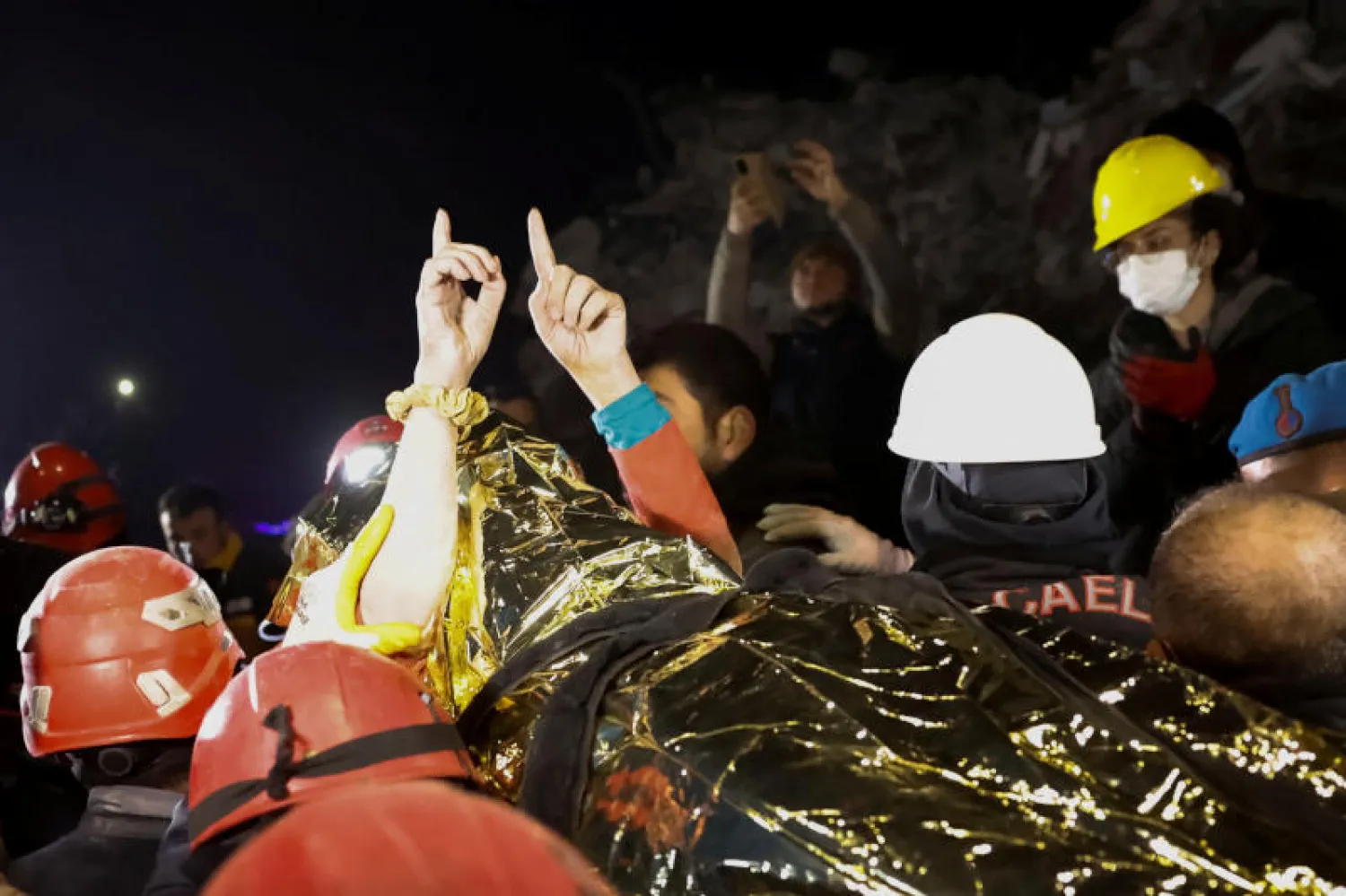 مسعفون يحملون فتاة بعد انتشالها من تحت الأنقاض في مدينة هطاي التركية اليوم (رويترز)