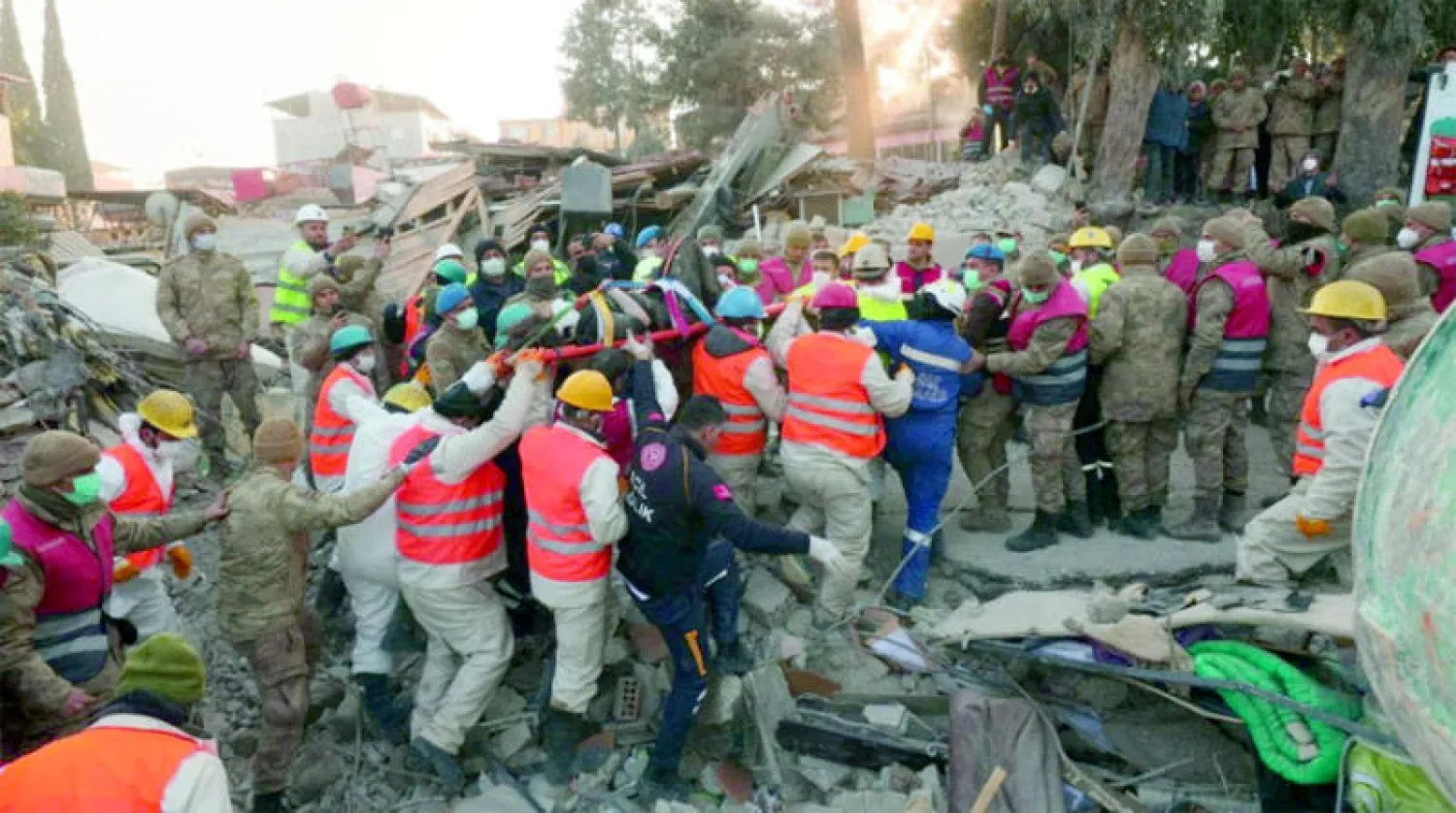 حشد من عمال الإنقاذ الأتراك والأجانب يساعد على انتشال ناجية من تحت الأنقاض في هطاي (رويترز)