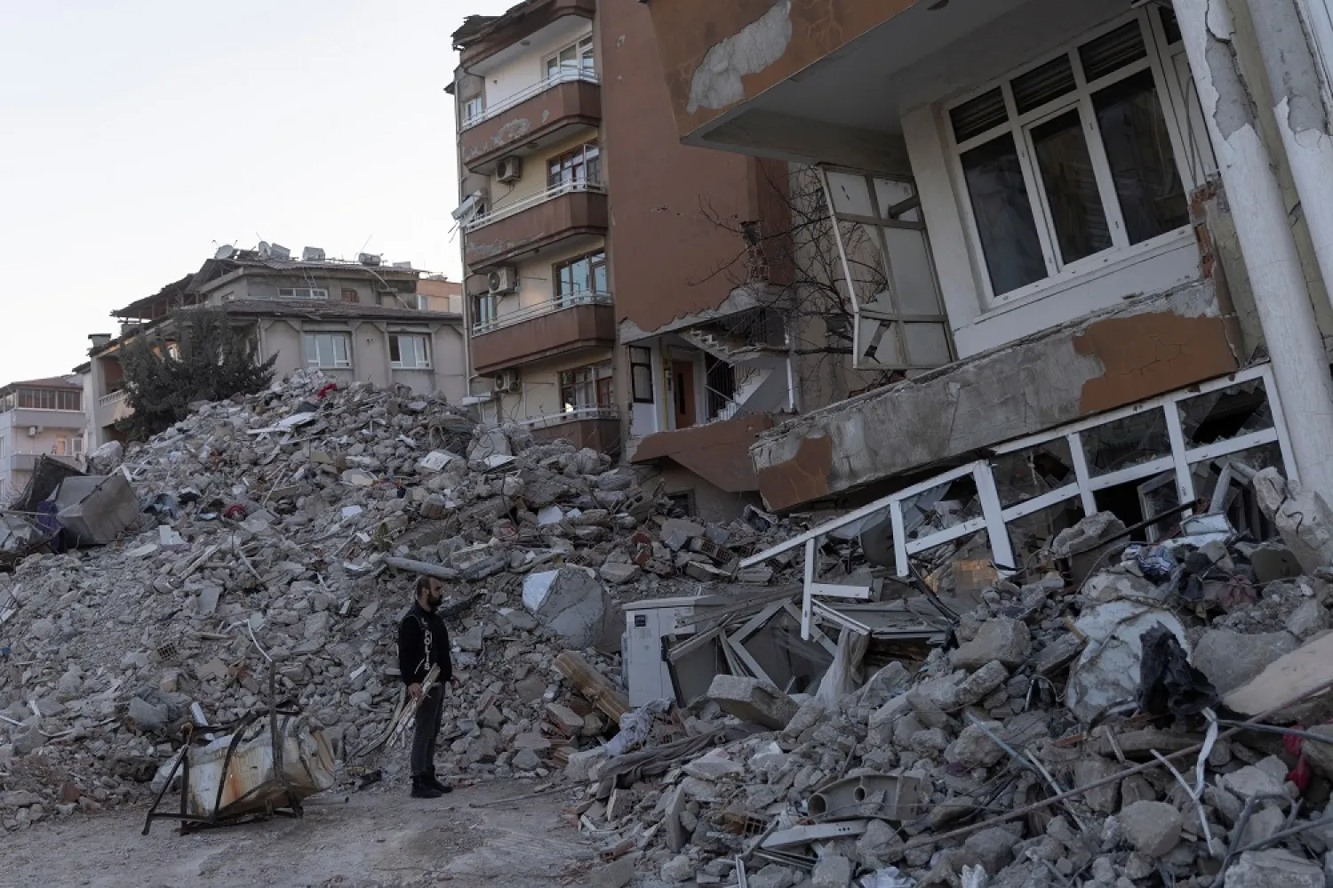 A man stands in front of a destroyed building in the aftermath of the deadly earthquake in Hatay, Türkiye, February 18, 2023. (Reuters)