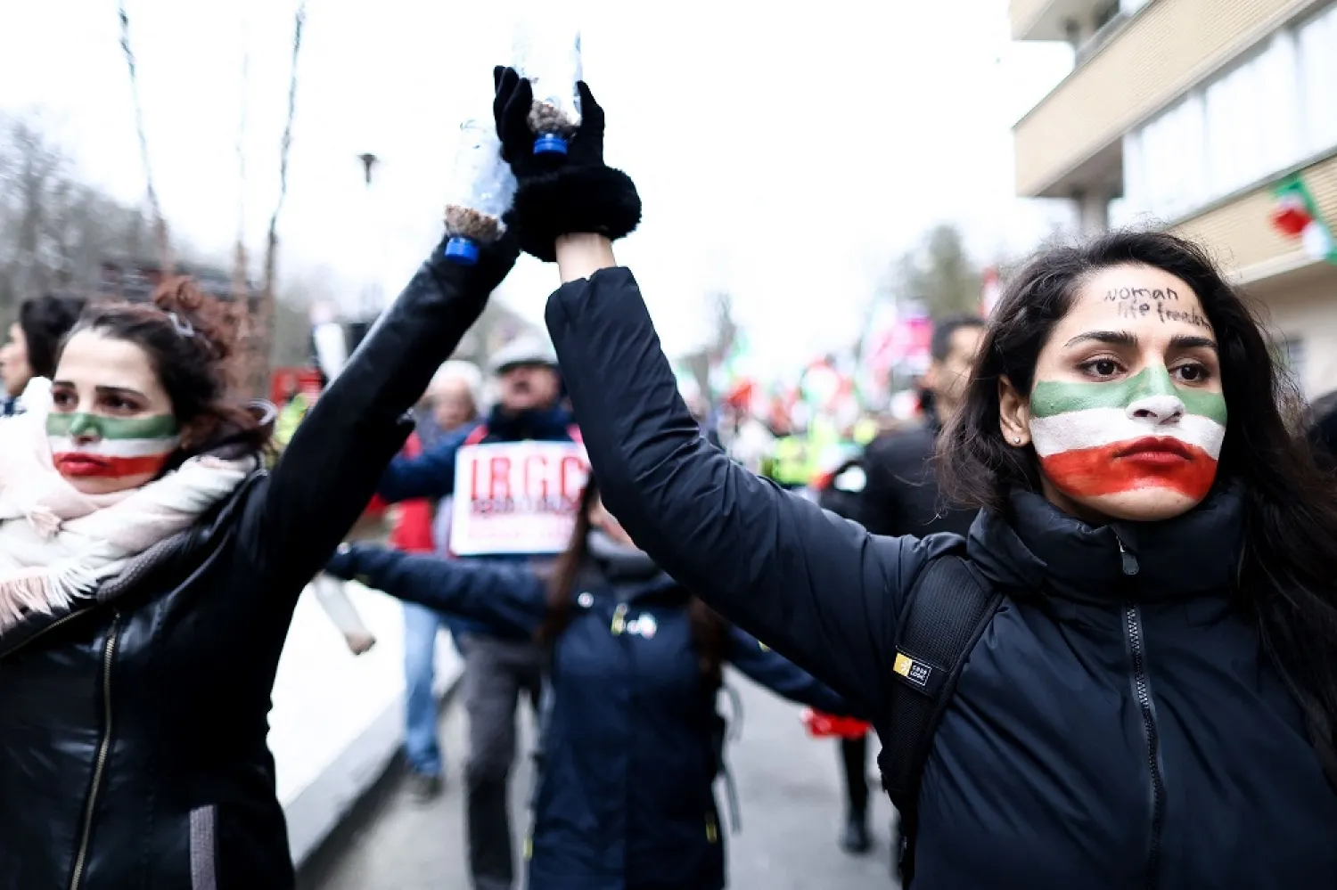 A protestor with the Iranian flag painted on her face takes part during a protest supporting Iranian resistance movement in Brussels on February 20, 2023. (AFP) 