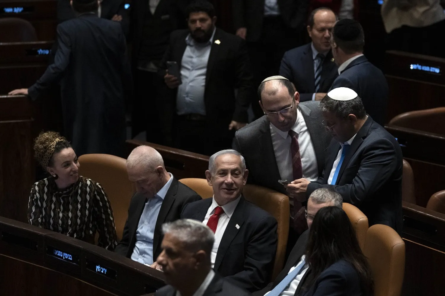 Israel's Prime Minister Benjamin Netanyahu, center, and lawmakers congratulate Justice Minister Yariv Levin, in blue tie at right foreground, after his speech in Israel's parliament, the Knesset, just before a vote on a contentious plan to overhaul the country's legal system, in Jerusalem, early Tuesday, Feb. 21, 2023. (AP)