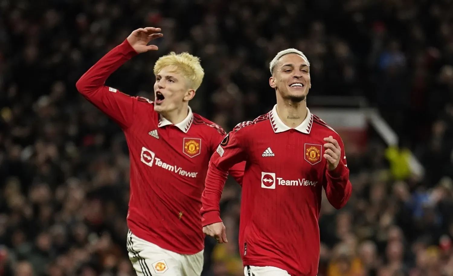 Manchester United's Antony, right, celebrates after scoring his side's second goal during the Europa League playoff second leg match between Manchester United and Barcelona at Old Trafford stadium in Manchester, England, Thursday, Feb. 23, 2023. (AP)