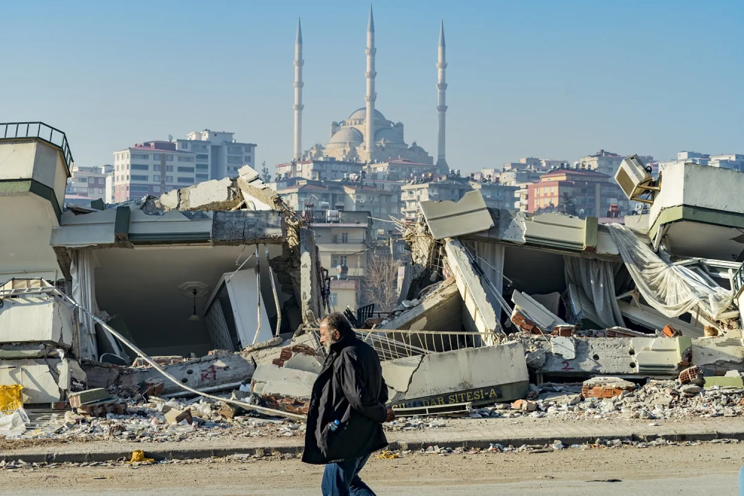 18 February 2023, Türkiye, Kahramanmaras: A man walks past a building that was destroyed by the deadly earthquake that struck the Turkish provinces of Hatay and Kahramanmaras. (dpa)